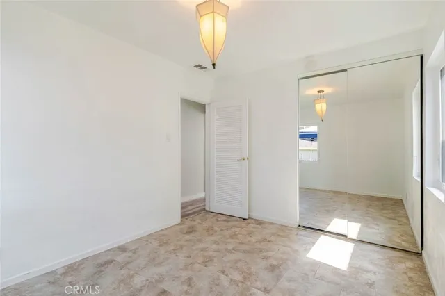 an empty room with closet and windows