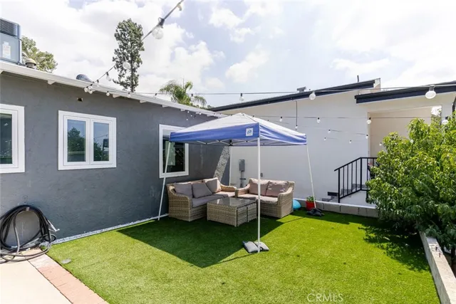 a backyard of a house with table and chairs