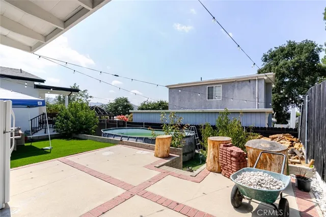 a view of a patio with table and chairs potted plants and a palm tree