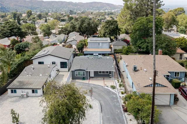 an aerial view of a house with a yard and mountain