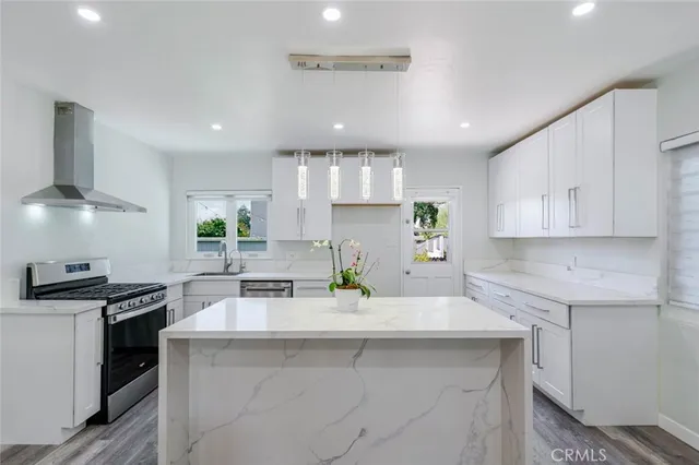 a kitchen with kitchen island granite countertop a sink stainless steel appliances and cabinets