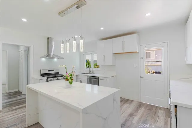 a kitchen with kitchen island a stove a sink and a refrigerator