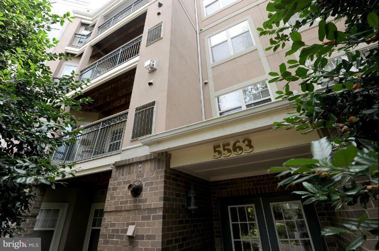 a front view of a building with a tree