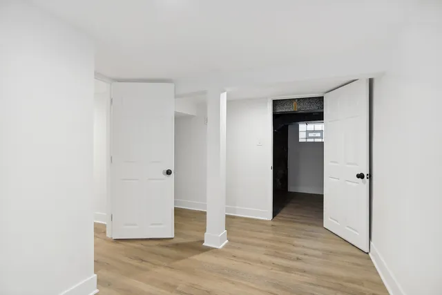 a view of an empty room with wooden floor