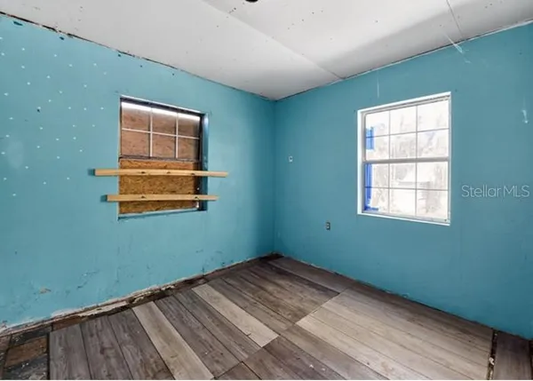 a view of a room with wooden floor and windows