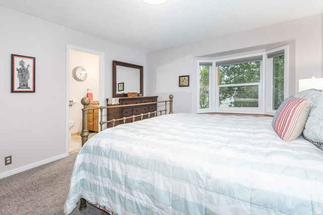 10183 Hickory Point Drive Sandy, UT 84092 - Photo 21 of 36 Spacious bedroom featuring a large bay window, light gray walls, and plush carpeting
