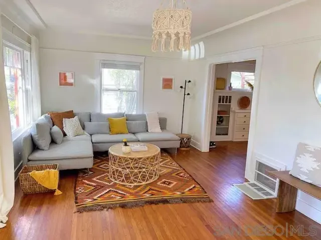 a living room with furniture and wooden floor