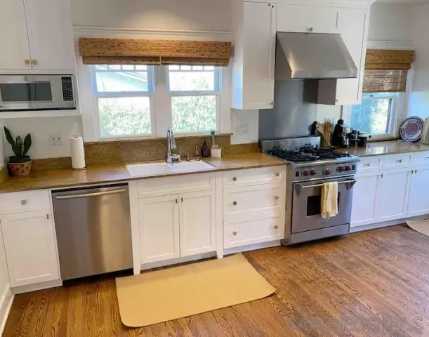a kitchen with stainless steel appliances a stove a sink and a microwave