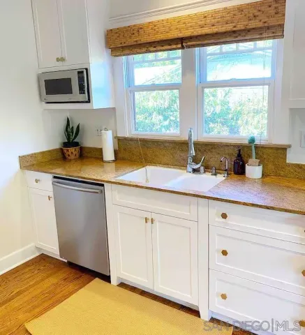 a kitchen with stainless steel appliances granite countertop a sink and a window