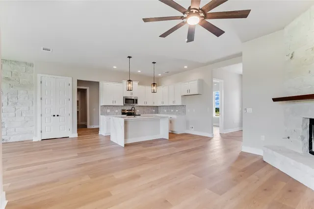 a kitchen with a sink a microwave and cabinets