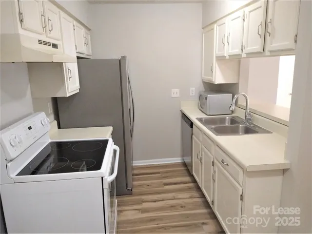 a kitchen with a sink and a stove top oven