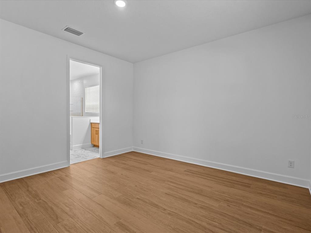 8018 Colby Circle Orlando, FL 32817 - Photo 13 of 32 a view of an empty room with wooden floor and a window