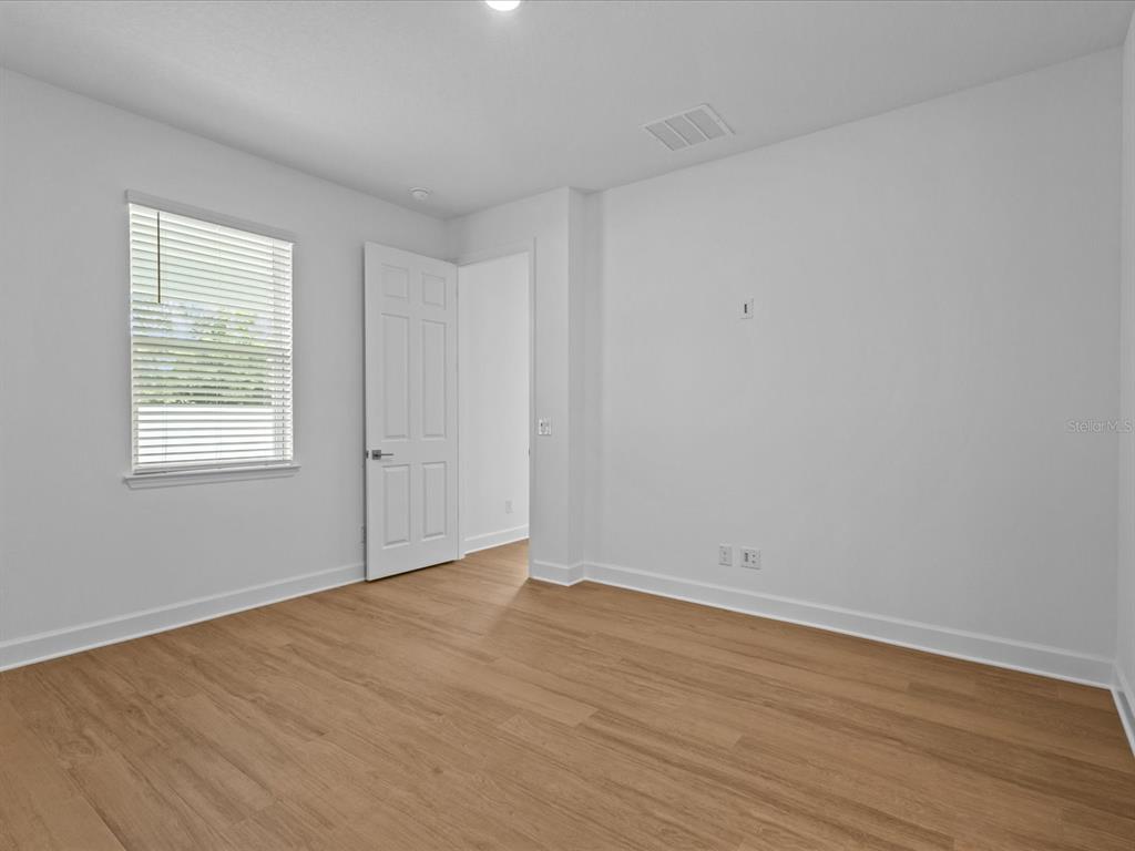 8018 Colby Circle Orlando, FL 32817 - Photo 16 of 32 a view of an empty room with wooden floor and a window