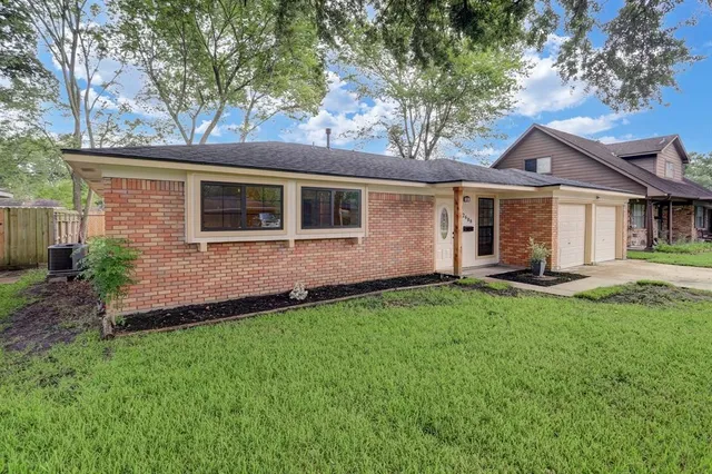 a front view of a house with a yard and green space