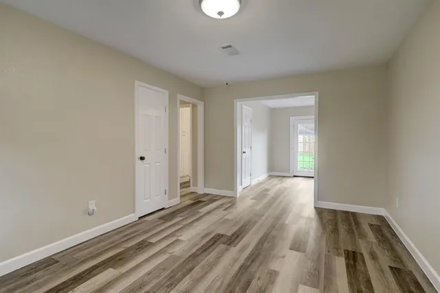 a view of a room with wooden floor and a bathroom