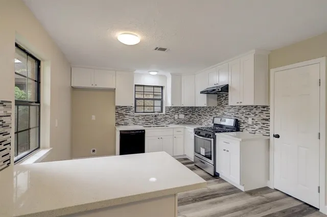 a kitchen with a refrigerator stove top oven and sink
