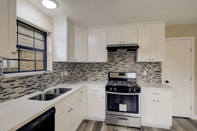 a kitchen with stove a sink and a microwave