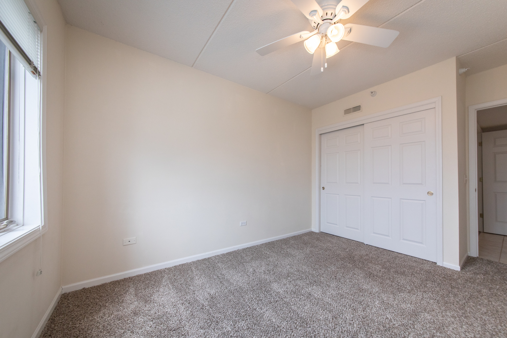 650 South River Road, Unit 601 Des Plaines, IL 60016 - Photo 14 of 20 an empty room with windows and fan