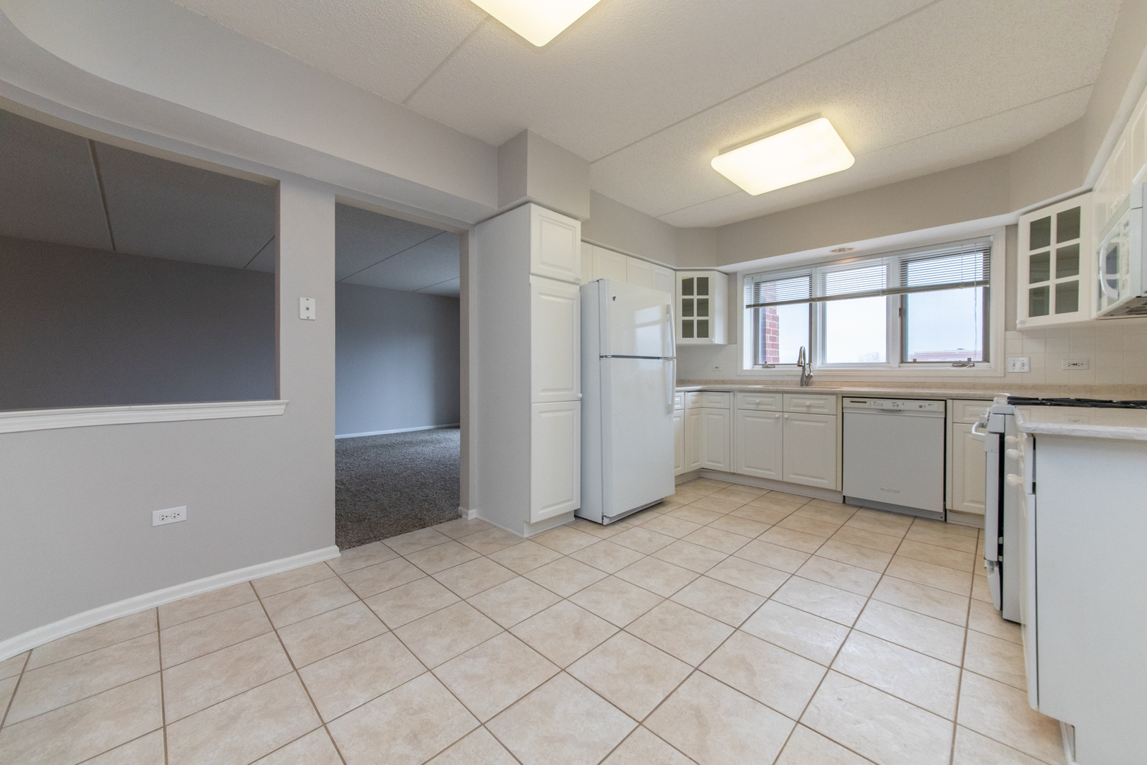 650 South River Road, Unit 601 Des Plaines, IL 60016 - Photo 8 of 20 a view of a kitchen with white cabinets and refrigerator