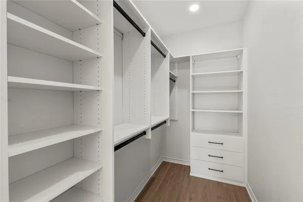 a view of walk in closet with empty racks