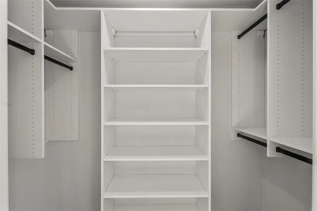 a view of walk in closet with empty racks