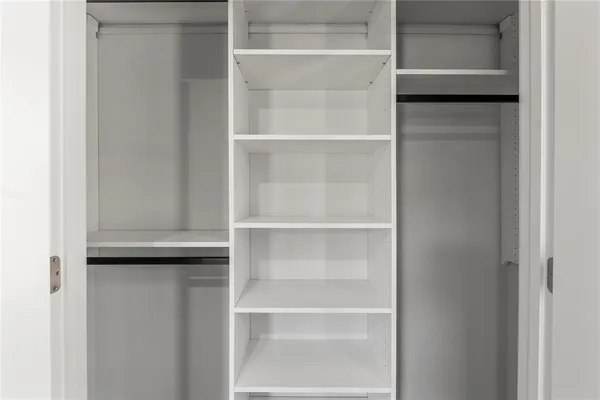 a view of walk in closet with empty racks