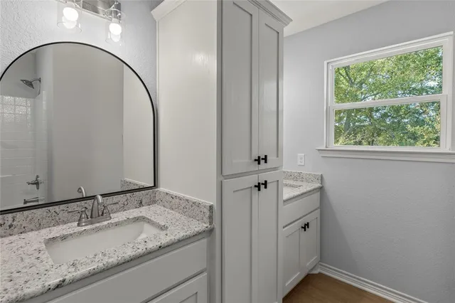 a bathroom with a granite countertop sink and a mirror