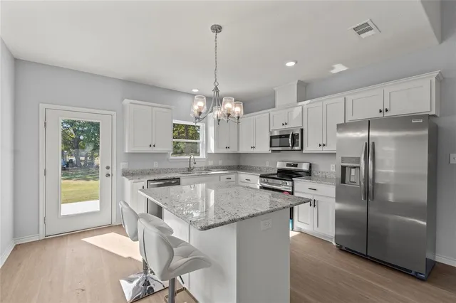 a kitchen with stainless steel appliances granite countertop a sink stove and refrigerator
