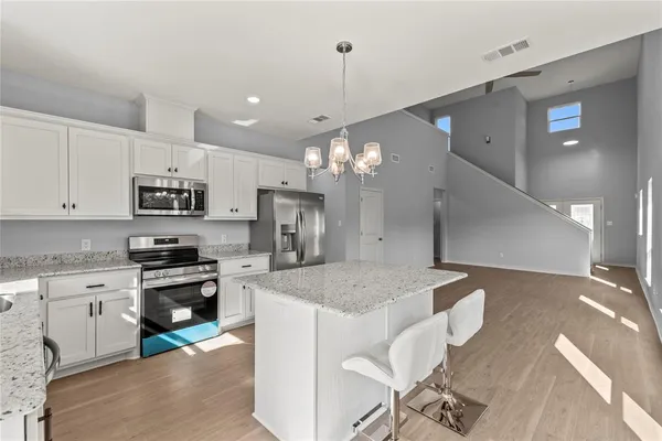 a kitchen with kitchen island a sink stainless steel appliances and a counter top space