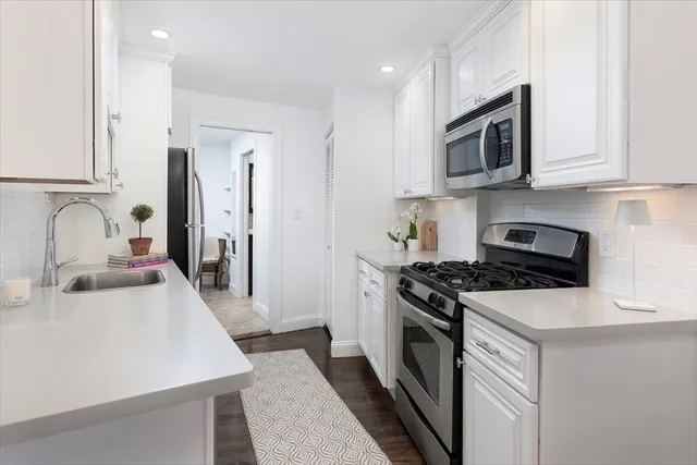 a kitchen with stainless steel appliances granite countertop a sink stove and microwave