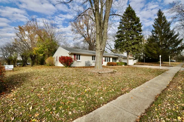 a front view of a house with large trees