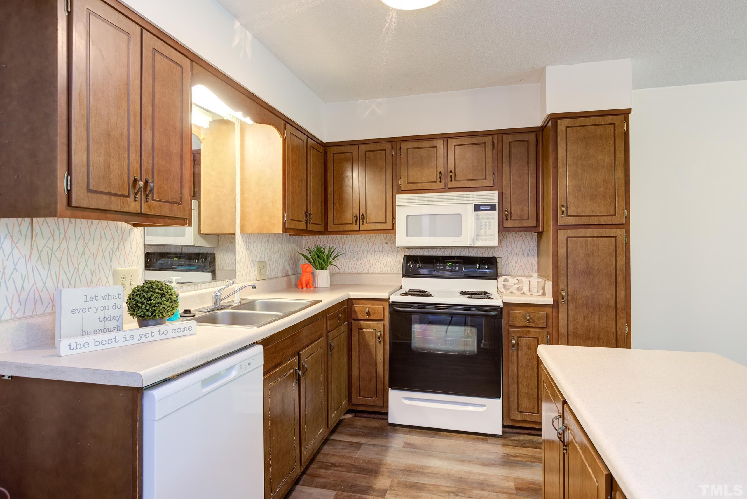 5060 Flint Ridge Place, Unit 5060 Raleigh, NC 27609 - Photo 12 of 29 a kitchen with a stove sink and cabinets