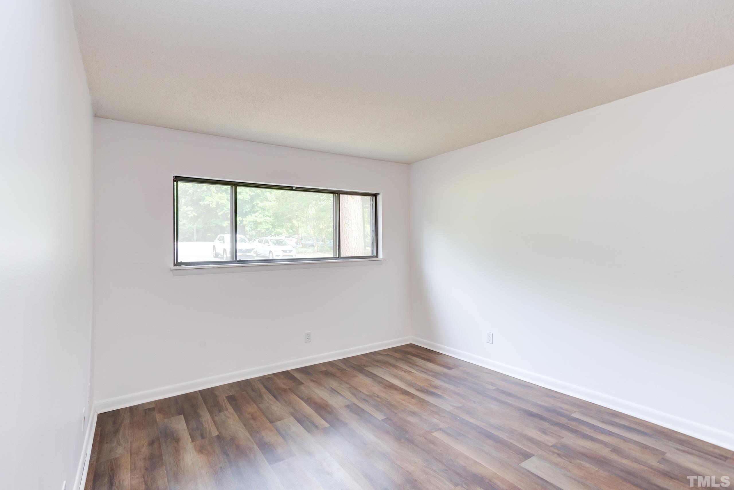 5060 Flint Ridge Place, Unit 5060 Raleigh, NC 27609 - Photo 17 of 29 an empty room with wooden floor and windows