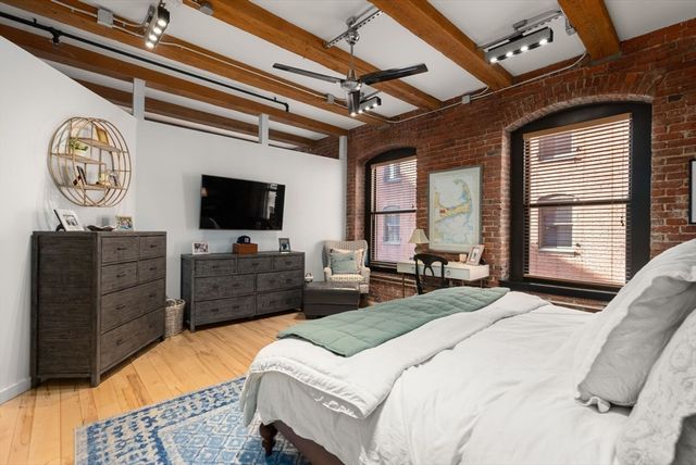 a bedroom with a bed dresser and flat screen tv