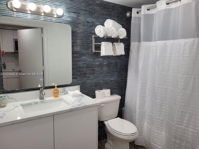 2889 McFarlane Road, Unit 1016 Miami, FL 33133 - Photo 6 of 12 a bathroom with a toilet sink and mirror