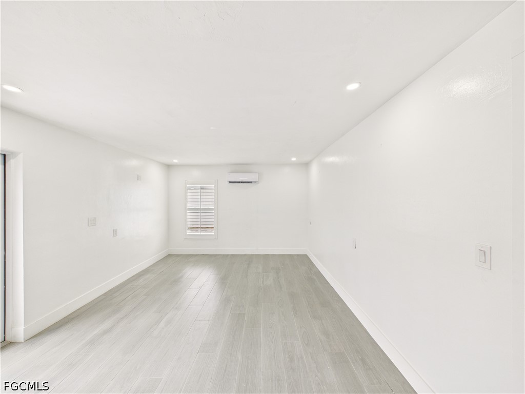 567 13th Street North Naples, FL 34102 - Photo 11 of 23 a view of a room with wooden floor and white walls