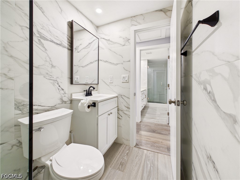 567 13th Street North Naples, FL 34102 - Photo 13 of 23 a bathroom with a sink a toilet a mirror and shower