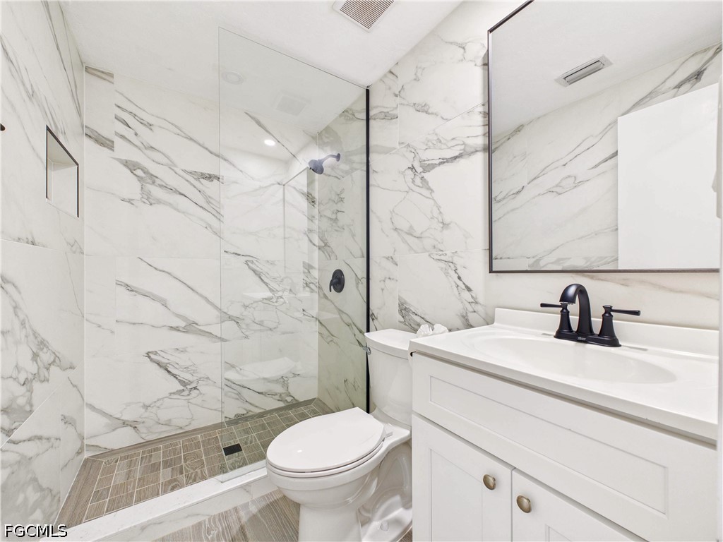 567 13th Street North Naples, FL 34102 - Photo 14 of 23 a bathroom with a sink toilet vanity and shower