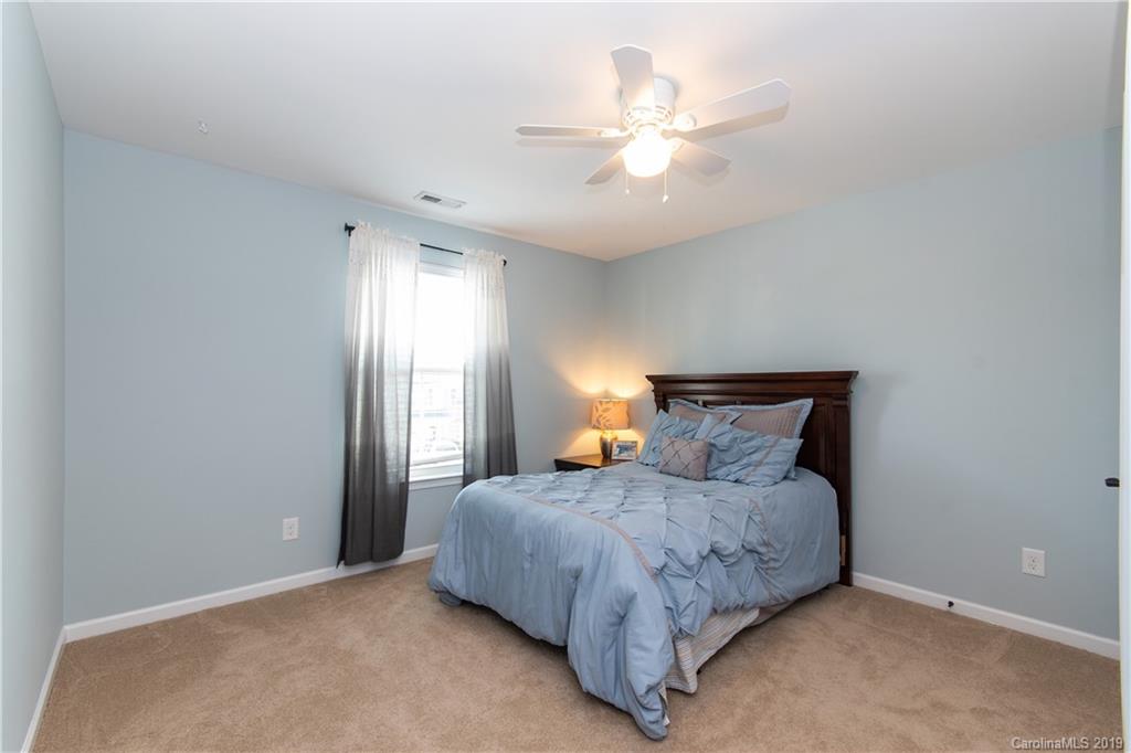 10937 Tailwater Street Davidson, NC 28036 - Photo 20 of 34 a bedroom with a bed and a chandelier