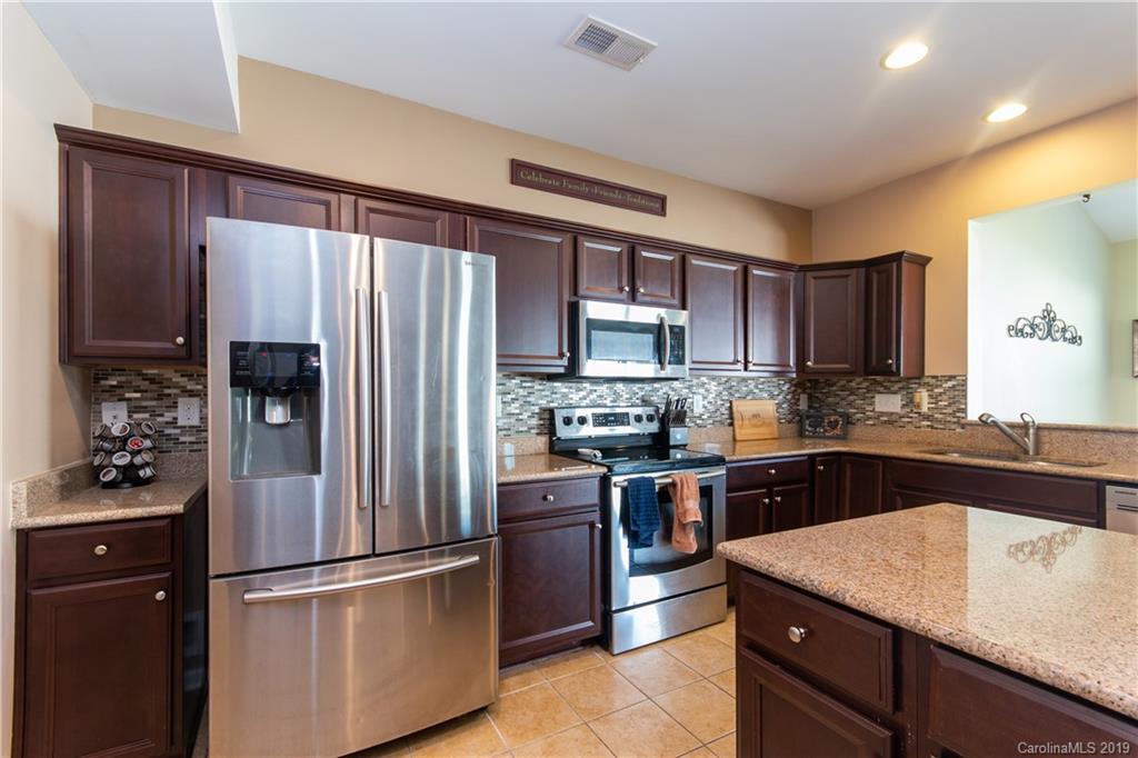 10937 Tailwater Street Davidson, NC 28036 - Photo 7 of 34 a kitchen with stainless steel appliances granite countertop a refrigerator stove and sink