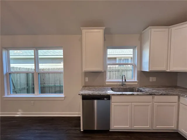 a kitchen with stainless steel appliances granite countertop a sink a stove and a window