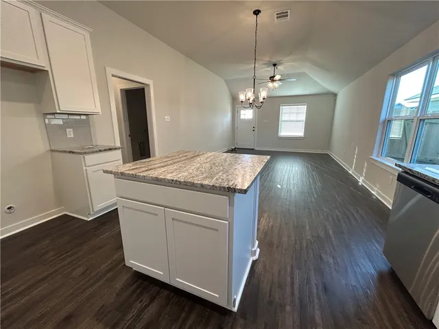 a view of kitchen with granite countertop cabinets wooden floor and a chandelier
