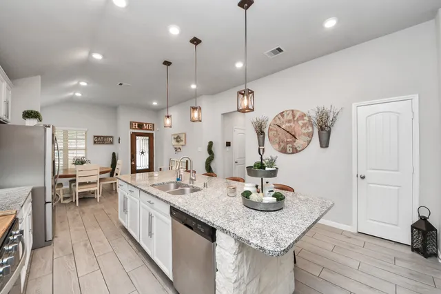 a kitchen with granite countertop a table chairs and wooden floor