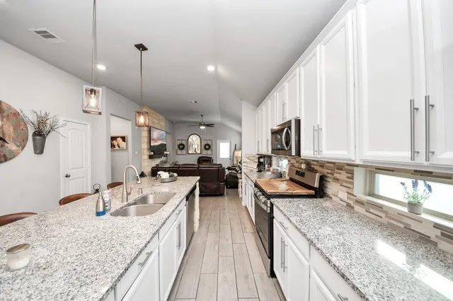 a kitchen with stainless steel appliances granite countertop sink stove and refrigerator