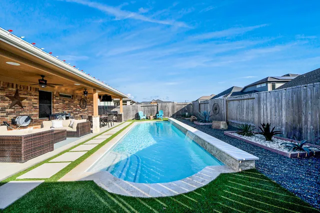 a view of a backyard with swimming pool