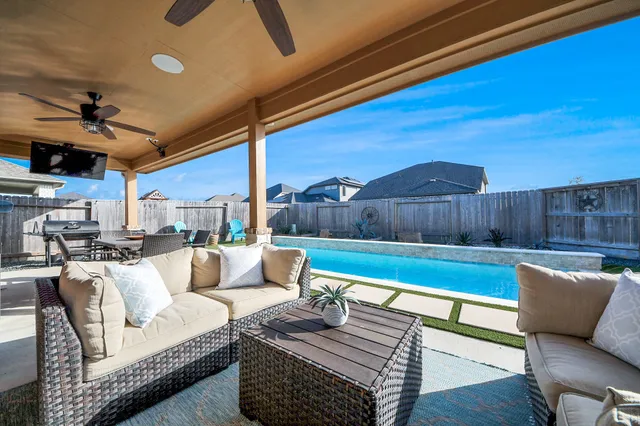 a living room with furniture a ceiling fan and a rug