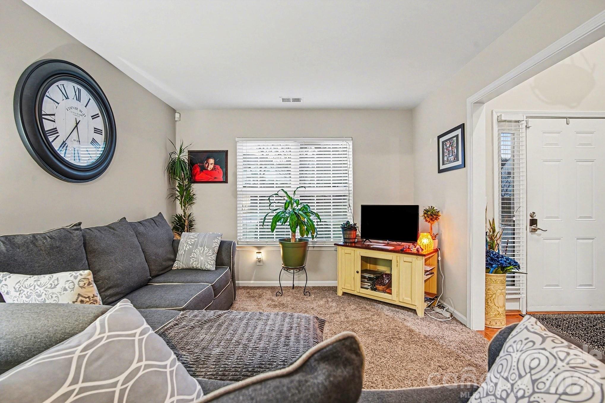 5625 Davis Ridge Drive Charlotte, NC 28269 - Photo 15 of 27 a living room with furniture a flat screen tv and a wall clock