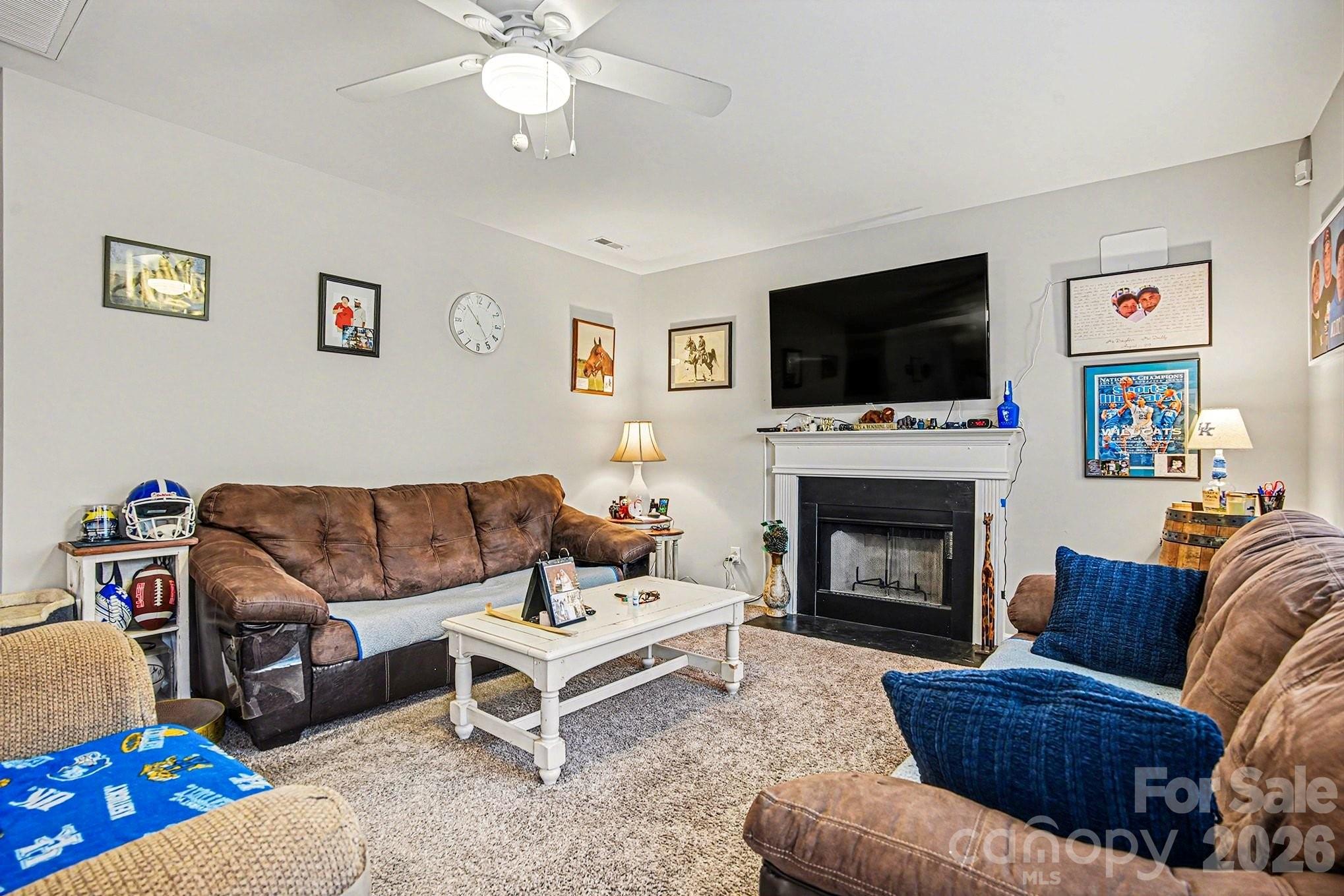 5625 Davis Ridge Drive Charlotte, NC 28269 - Photo 7 of 27 a living room with furniture a flat screen tv and a fireplace