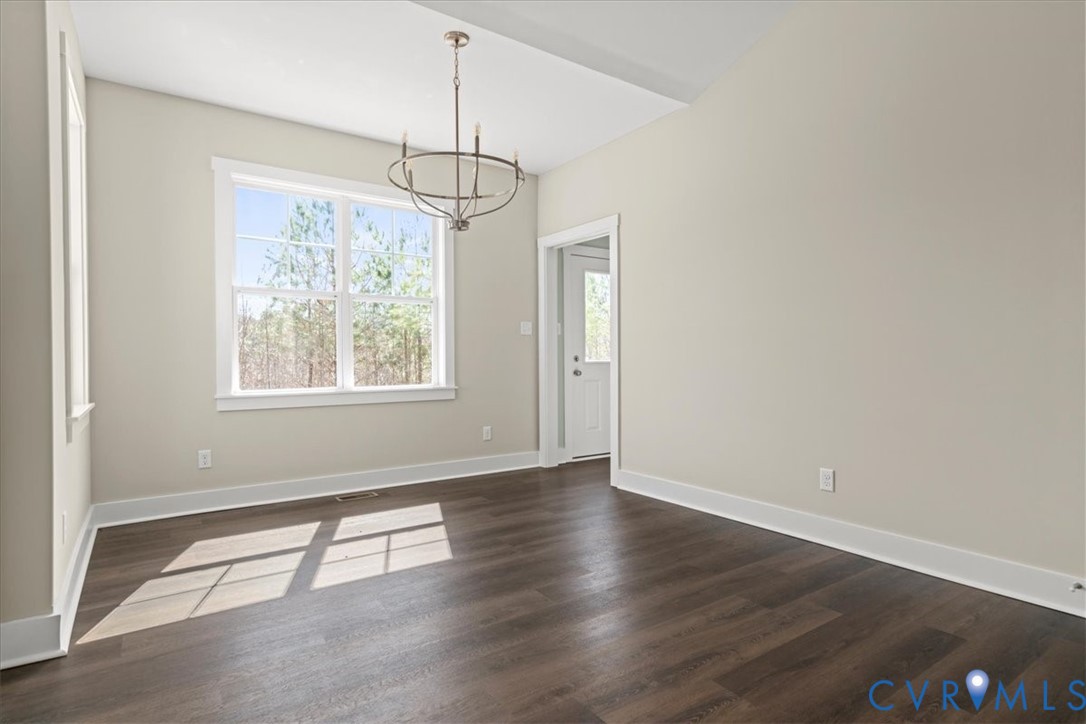 1191 Lewiston Plank Road Burkeville, VA 23922 - Photo 11 of 29 an empty room with wooden floor chandelier and windows