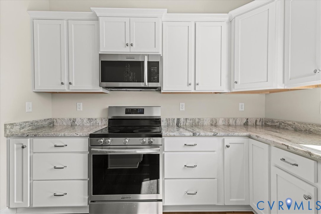 1191 Lewiston Plank Road Burkeville, VA 23922 - Photo 9 of 29 a kitchen with granite countertop white cabinets and stainless steel appliances